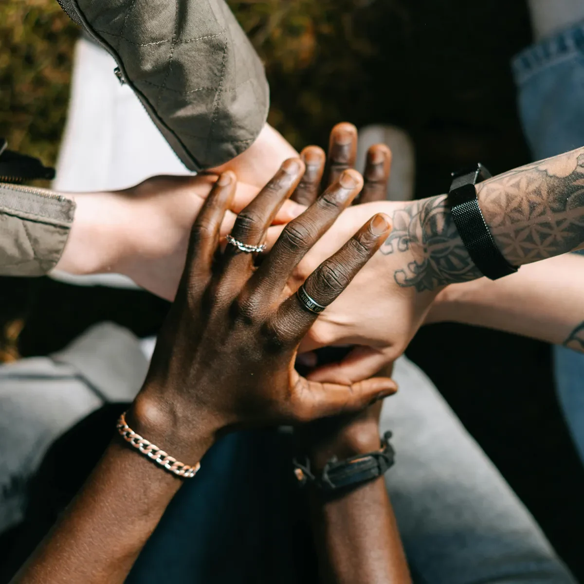 Groupe diversifié de personnes empilant leurs mains en signe d’unité et de collaboration