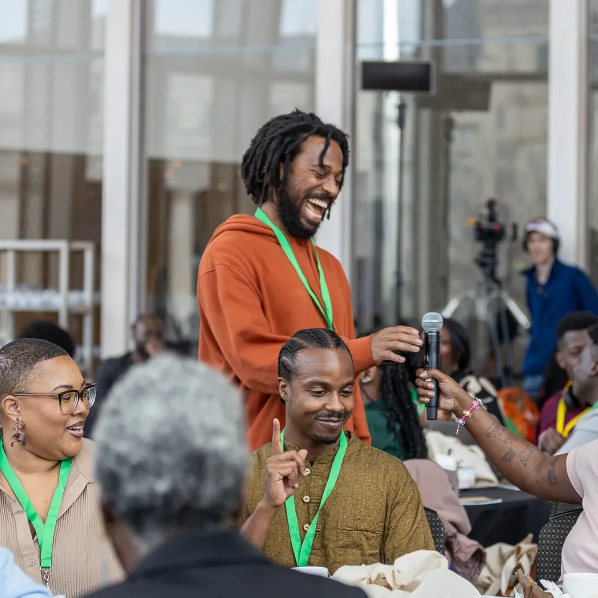 Groupe de personnes en discussion, souriant et échangeant dans un contexte collaboratif