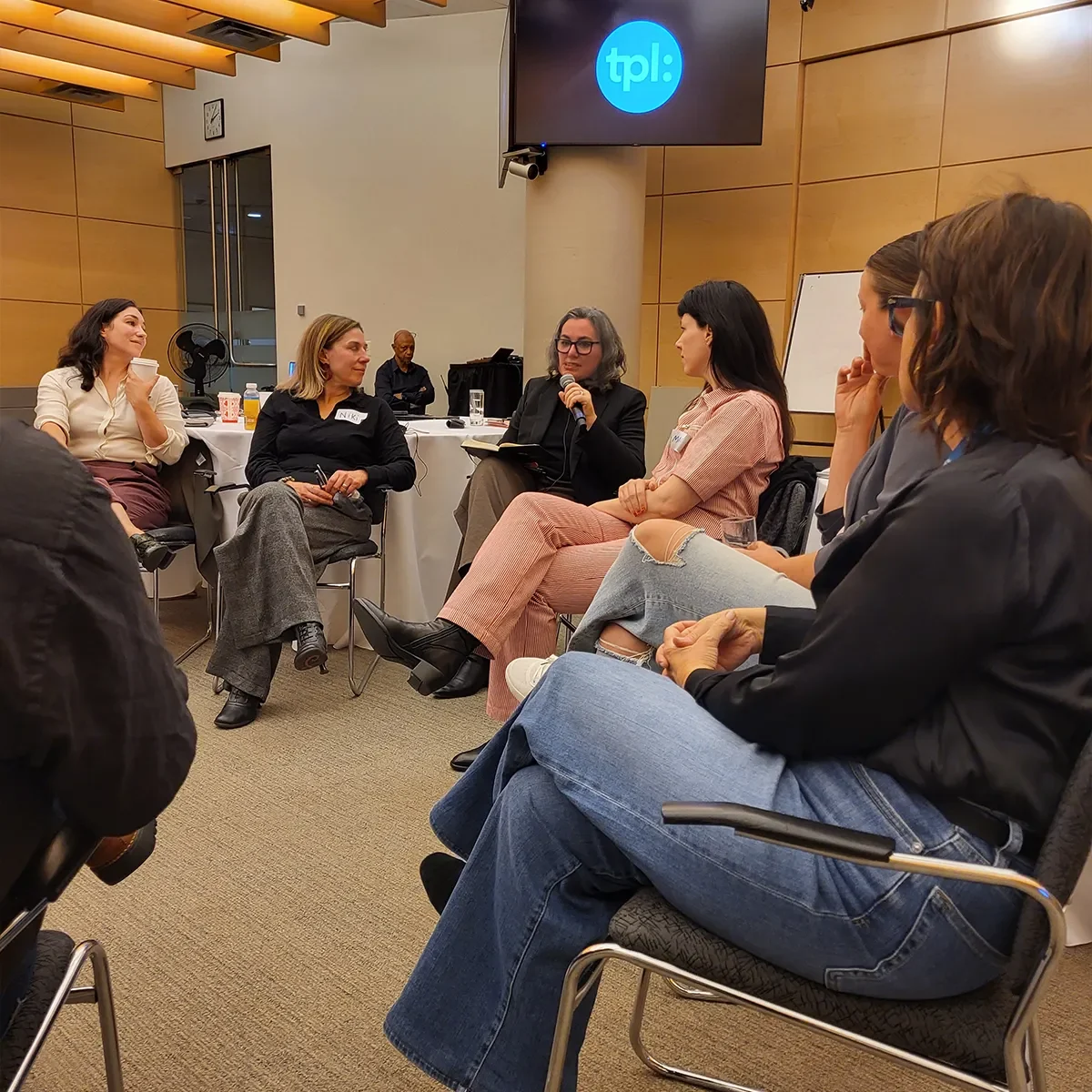 Groupe de personnes assises en cercle participant à une discussion dans une salle de réunion