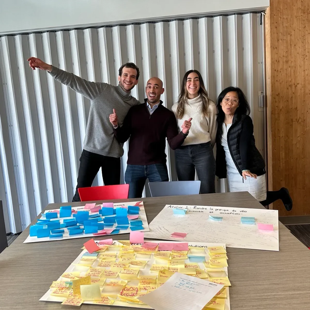 Groupe de personnes collaborant autour d’une table remplie de notes autocollantes lors d’un atelier